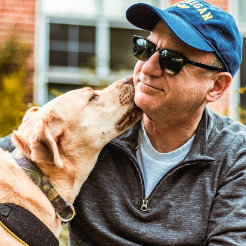hombre mayor junto a su perro labrador
